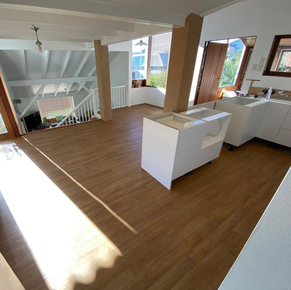 Wood grain vinyl plank flooring in a bright open-plan kitchen and living area